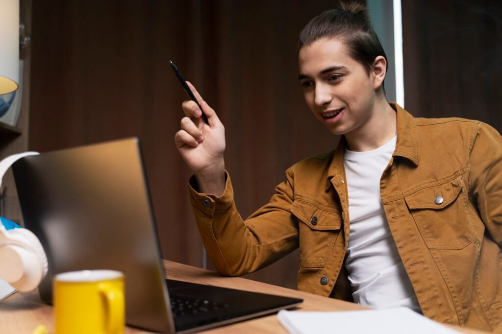 Teenage boy having video call at home on laptop